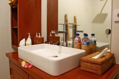 a bathroom with a white sink and a mirror at Villa Kicen Ubud in Ubud