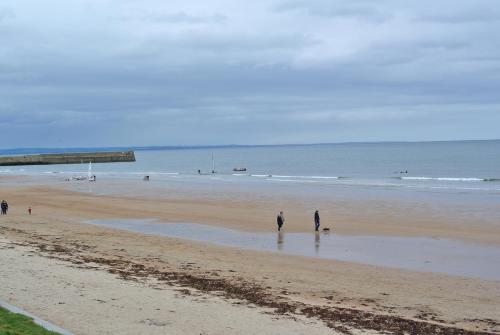 
people walking on a beach near the ocean at St Andrews Holiday Home in St. Andrews
