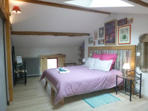 a bedroom with a large bed with a pink bedspread at Les Terrasses De Bessou in Clermont-Dessous