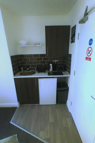 a small kitchen with a sink and a stove at Castle Terrace (B3 R3) in Dudley