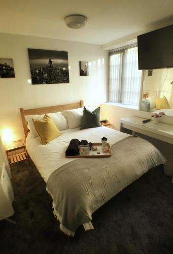 a bedroom with a large bed with a tray on it at Castle Terrace (B3 R3) in Dudley