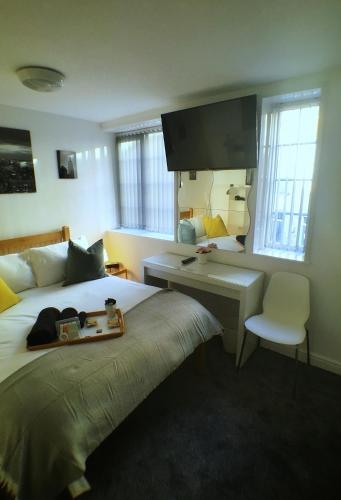 a hotel room with a bed with a desk and a monitor at Castle Terrace (B3 R3) in Dudley