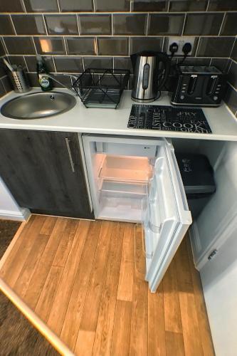an open refrigerator in a kitchen with a sink at Castle Terrace (B3 R3) in Dudley