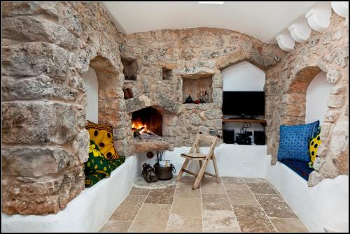 a room with a stone wall with a fireplace at "IL BOSCO" di POZZO VOLITO in Patù