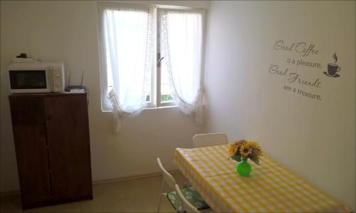 Una habitación con una mesa con un jarrón de flores. en APP Veselica, en Umag