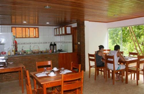zwei Personen sitzen an einem Tisch in einem Restaurant in der Unterkunft Pousada Sereia Dourada in Itacaré