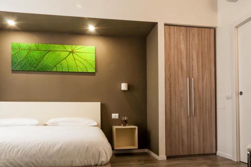 a bedroom with a bed and a green painting on the wall at VILLA FENIX OSIO SOTTO in Osio Sotto