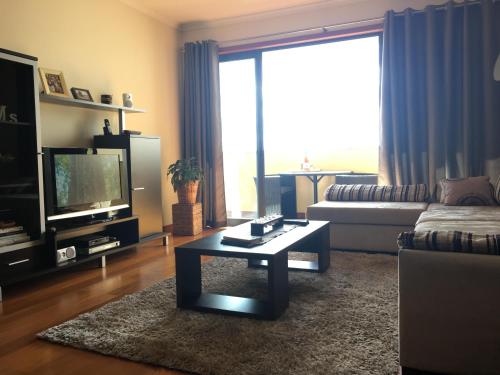 Una sala de estar con un sofá y una mesa de café. en Atlantis Apartment, en Câmara de Lobos