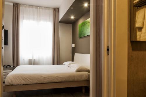a small bedroom with a bed and a window at VILLA FENIX OSIO SOTTO in Osio Sotto