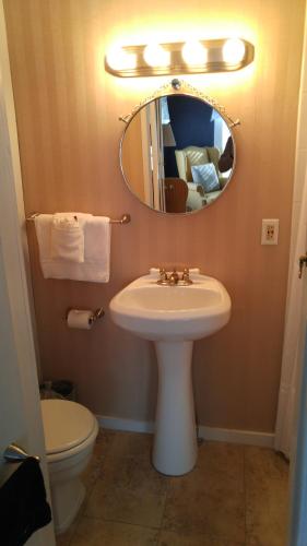 a bathroom with a sink and a mirror and a toilet at Benjamin Prescott Inn in Jaffrey