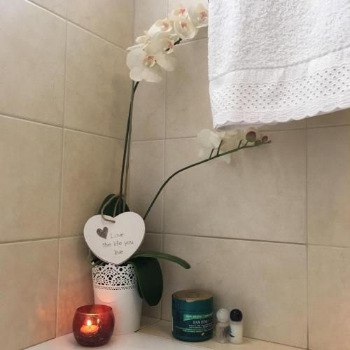 a vase with white flowers in a bathroom at Atlantis Apartment in Câmara de Lobos
