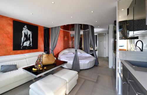 a living room with a white couch and a bed at Elixxir in Cap d'Agde