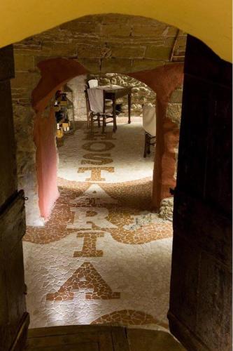 a stone archway with a table and chairs in a room at Hostaria da Lino in San Marino