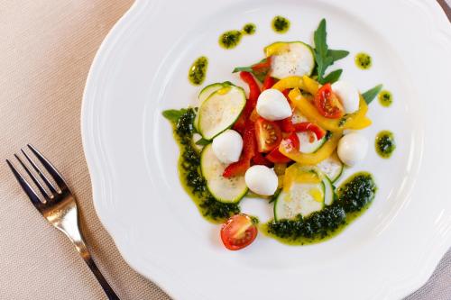 a plate of food with vegetables in the shape of a face at feldthurnerhof vinum-natur-relax in Feldthurns
