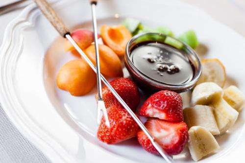 a plate of fruit with a bowl of dip at feldthurnerhof vinum-natur-relax in Feldthurns