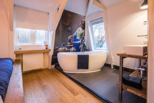 Eine Frau steht in einem Badezimmer mit Badewanne in der Unterkunft B&B Numero 14 in Amsterdam