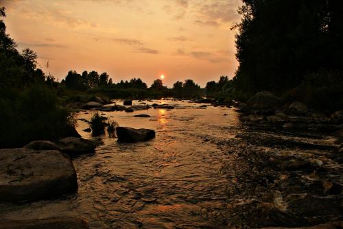 a group of people crossing a river at sunset at Pärus Fors in Lapväärtti