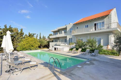a villa with a swimming pool and a building at Casa Manolesos in Chorafakia