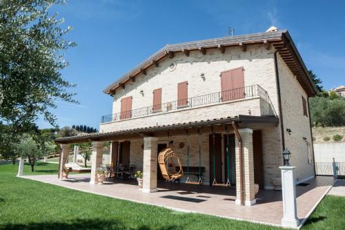 an old building with a balcony on a lawn at B&B L' Antica Fonte in Spinetoli