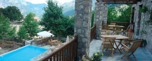 a balcony with a table and a swimming pool at Lefteri's & Loukia's Guesthouse in Neraida