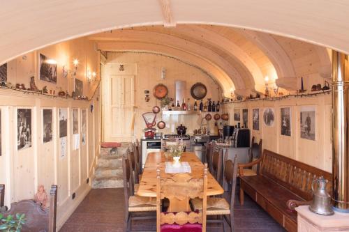 a dining room with a table and a kitchen at R&B La Gerla Blu in Tolmezzo