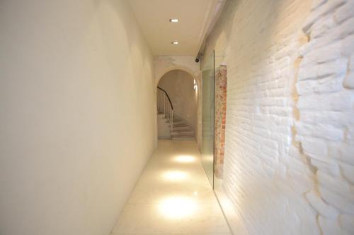 a hallway with a white brick wall with a light on it at Scaravelli Residenza in Mantova