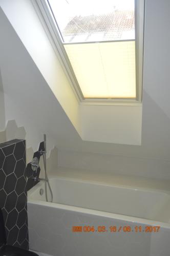 a bathroom with a window and a bath tub at Aloza in Ustka