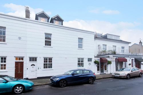 three cars parked in front of a white building at Great Loft & Location by Belsize Park tube in London