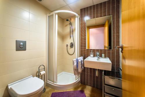 een badkamer met een douche, een toilet en een wastafel bij Apartamentos Amanecer JC1 in Murcia