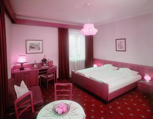 a bedroom with a bed and a desk and a table at Plonerhof in Lagundo