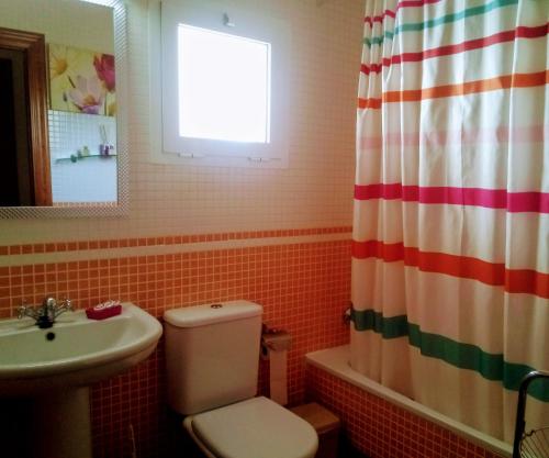 a bathroom with a toilet and a sink and a window at Al-Andalus Thalassa Home Star in Vera
