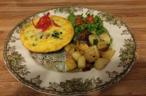 a plate of food with potatoes and vegetables on a table at Benjamin Prescott Inn in Jaffrey