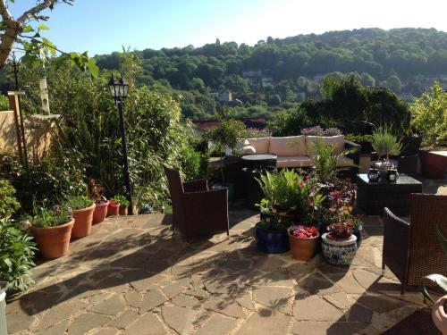 a patio with potted plants and a table and chairs at Highview Bed and Breakfast in Nailsworth