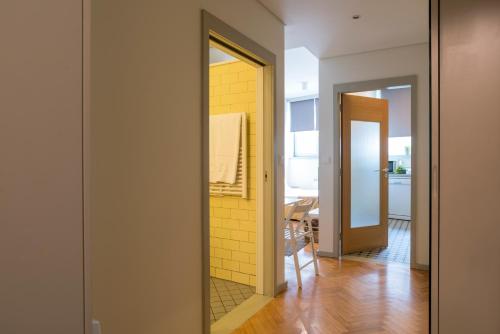 un couloir avec un miroir et un mur jaune dans l'établissement bnapartments Trindade, à Porto