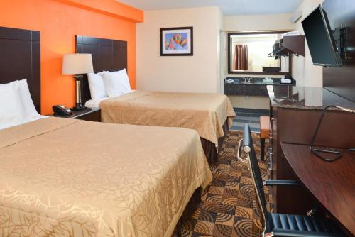 コラオポリスにあるAmericas Best Value Inn-Pittsburgh Airportのベッド2台、薄型テレビが備わるホテルルームです。