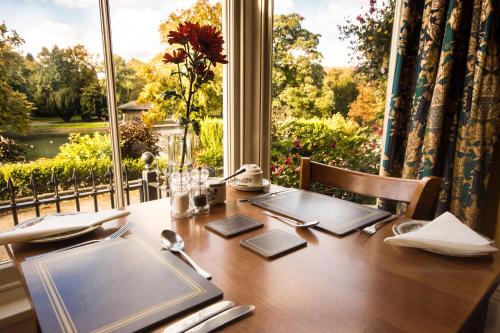 a dining room table with a view of a window at Roseleigh in Buxton