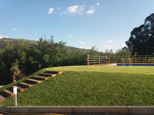 a grassy field with stairs leading to a playground at AntHouse in Amarante