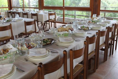a long table with white tablecloths and plates of food at Hotel Locanda Minerva in Monteleone Rocca Doria