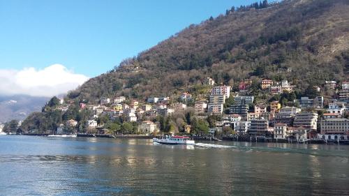 a boat on the water in front of a mountain at Al Porticciolo di Sant'Agostino in Como