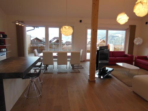 a dining room and living room with a table and a couch at Penthouse Alpine Living direkt an der Skipiste by Schladmingurlaub in Haus im Ennstal