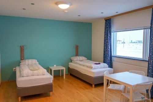凱夫拉維克的住宿－凱夫拉維克機場旅舍，客房设有两张床、一张桌子和一扇窗户。