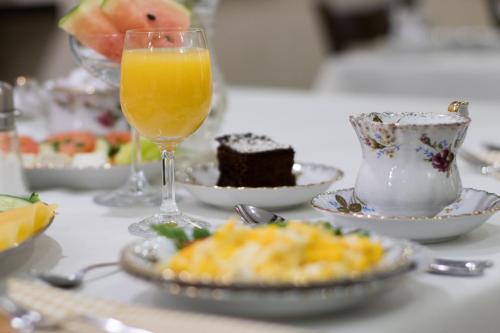 a table topped with plates of food and a glass of orange juice at Hotel Awo in Gniezno