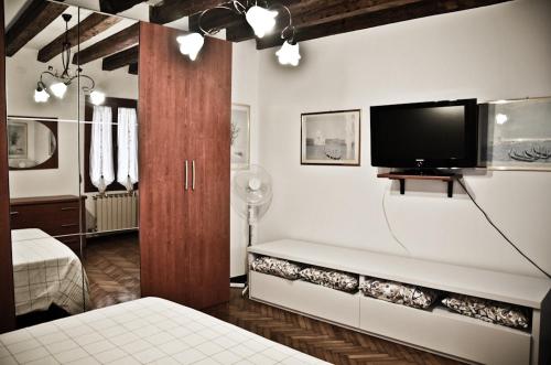 Un dormitorio con una cama y un televisor en la pared. en Appartamento grazioso e centrale, en Venecia