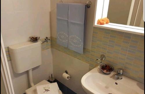 a bathroom with a toilet and a sink and a mirror at Casa Vacanza Brigida in Scopello