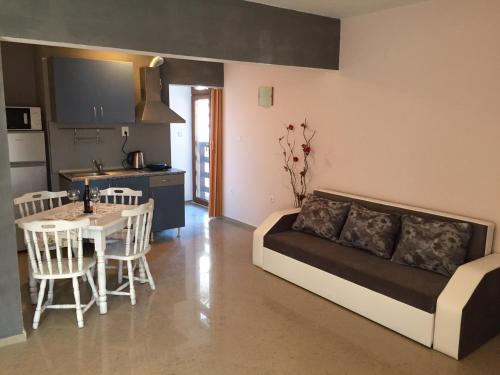 a living room with a couch and a table and a kitchen at Guest House Afrodita in Chernomorets