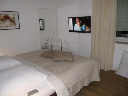 1 dormitorio con 1 cama y TV en la pared en Ferienwohnung Hamburg-Rosengarten, en Rosengarten