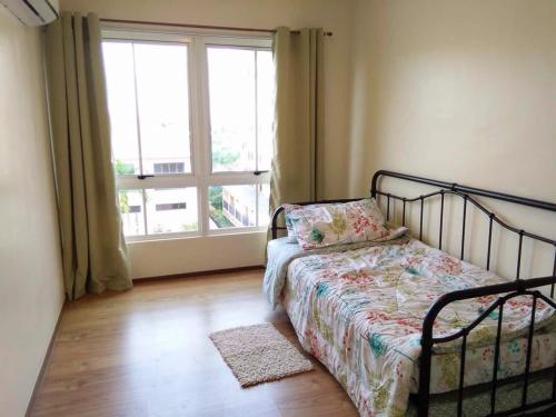 1 dormitorio con cama y ventana grande en Amalfi Oasis en Cebu City