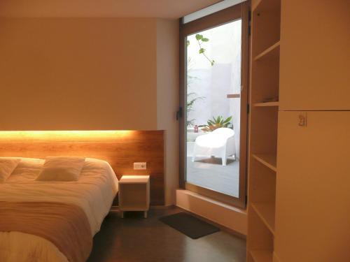 Un dormitorio con una cama y una ventana grande. en Apartamento Forn dels Apòstols, en Valencia