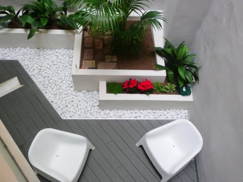 2 sillas blancas y plantas en una habitación en Apartamento Forn dels Apòstols, en Valencia