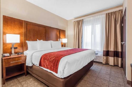 a hotel room with a large bed and a window at Comfort Suites in La Vista